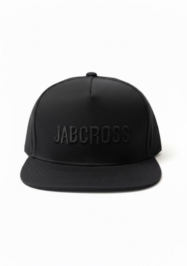 Black JABCROSS snapback cap with tonal front logo and red boxing glove “POW!” comic embroidery on the side, featuring a red underside visor.